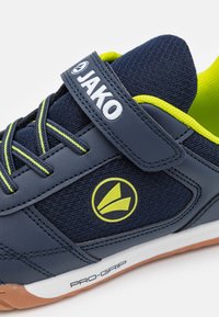Marineblaues Sportschuhmodell mit einem synthetischen Obermaterial, limegrünen Akzenten, Klettverschluss und strukturiertem Mesh. Verfügt über eine Gummisohle mit "PRO-GRIP" Branding.