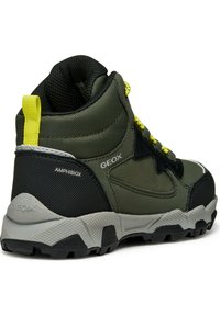 Botte de randonnée imperméable mi-haute verte avec des accents noirs et gris, des panneaux texturés et des lacets jaunes vifs. Équipée d'une semelle à crampons robuste.