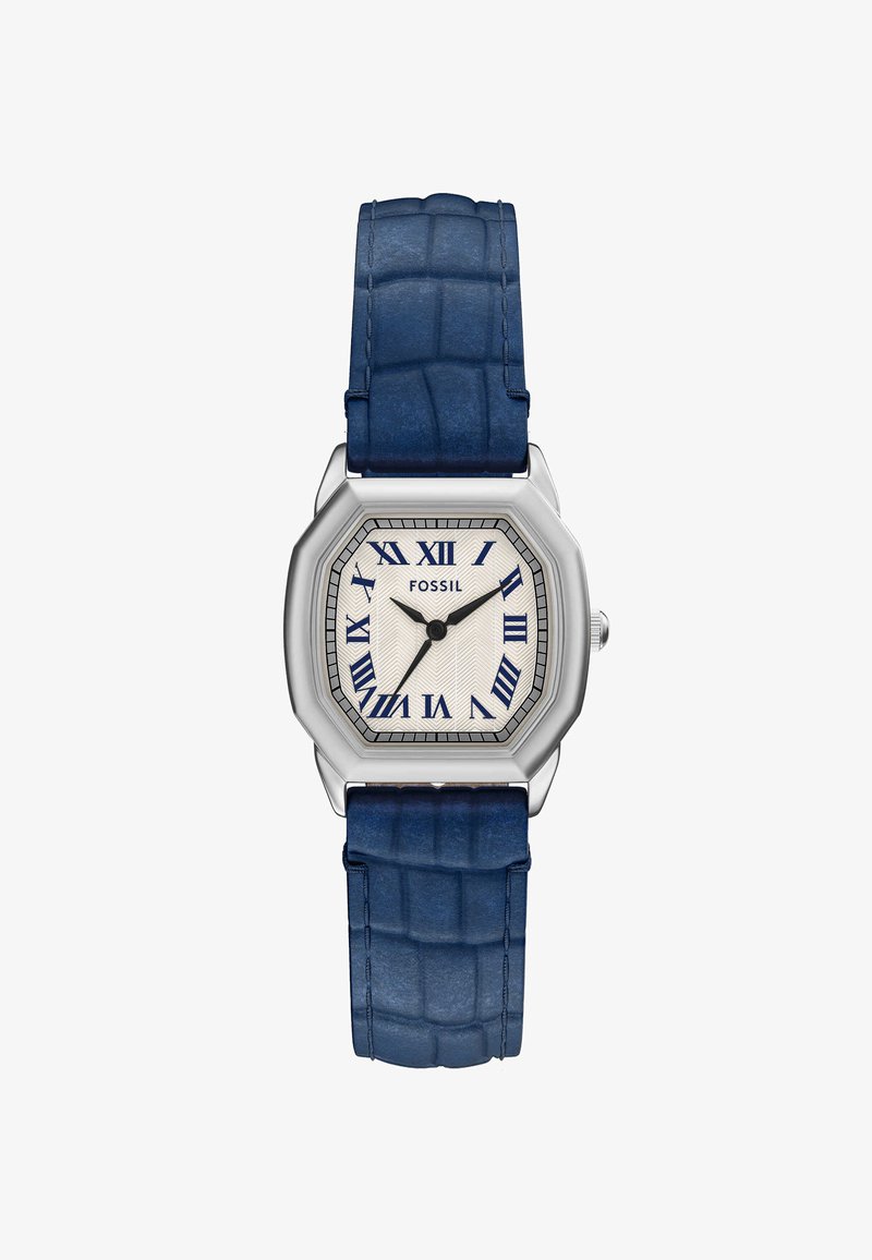 Harmaatonninen oktaavikello, jossa on teksturoitu vaalean beige kellotaulu, siniset Rooman numerot ja krokotiilinkuosisilla sinisellä nahkaremillä.