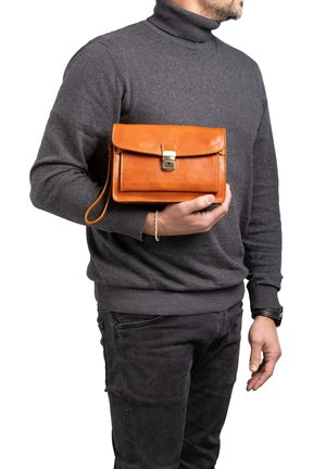 Oranje leren handtas met een klep, sluiting met een gesp en een polsband. Gladde textuur, rechthoekige vorm, gepresenteerd in een casual grip.