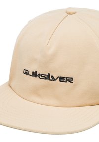 Béžová čiapka vyrobená z látky s plochým billom, na prednej strane s vyšitým čiernym logom "Quiksilver", s šitými detailmi a tónovou textúrou látky.