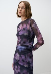 Paarse bloemenlange jurk met lange mouwen en een gerimpeld ontwerp. Heeft een getailleerde silhouet en een gladde textuur.