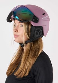 Rosa Skihelm mit blau getöntem Visier, gepolsterten Ohrenschützern und verstellbaren Riemen, mit einer strukturierten Schale für zusätzliche Haltbarkeit.