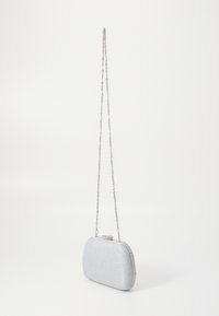 Borsa clutch metallica argento con forma arrotondata, superficie testurizzata e tracolla a catena. Presenta una chiusura decorativa nella parte superiore.