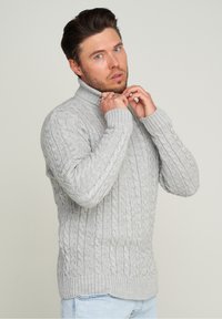 Hellgrauer, kabelgemusterter Rollkragenpullover mit gerippten Bündchen und Saum, der eine filigrane Textur und ein Muster aufweist, mit lässiger Passform.