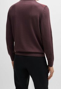 Gebreide pullover in diep bordeauxrood met lange mouwen, ronde hals en ribgebreide manchetten. Glad textuur, casual pasvorm, minimalistisch ontwerp en geen zichtbare logo's.