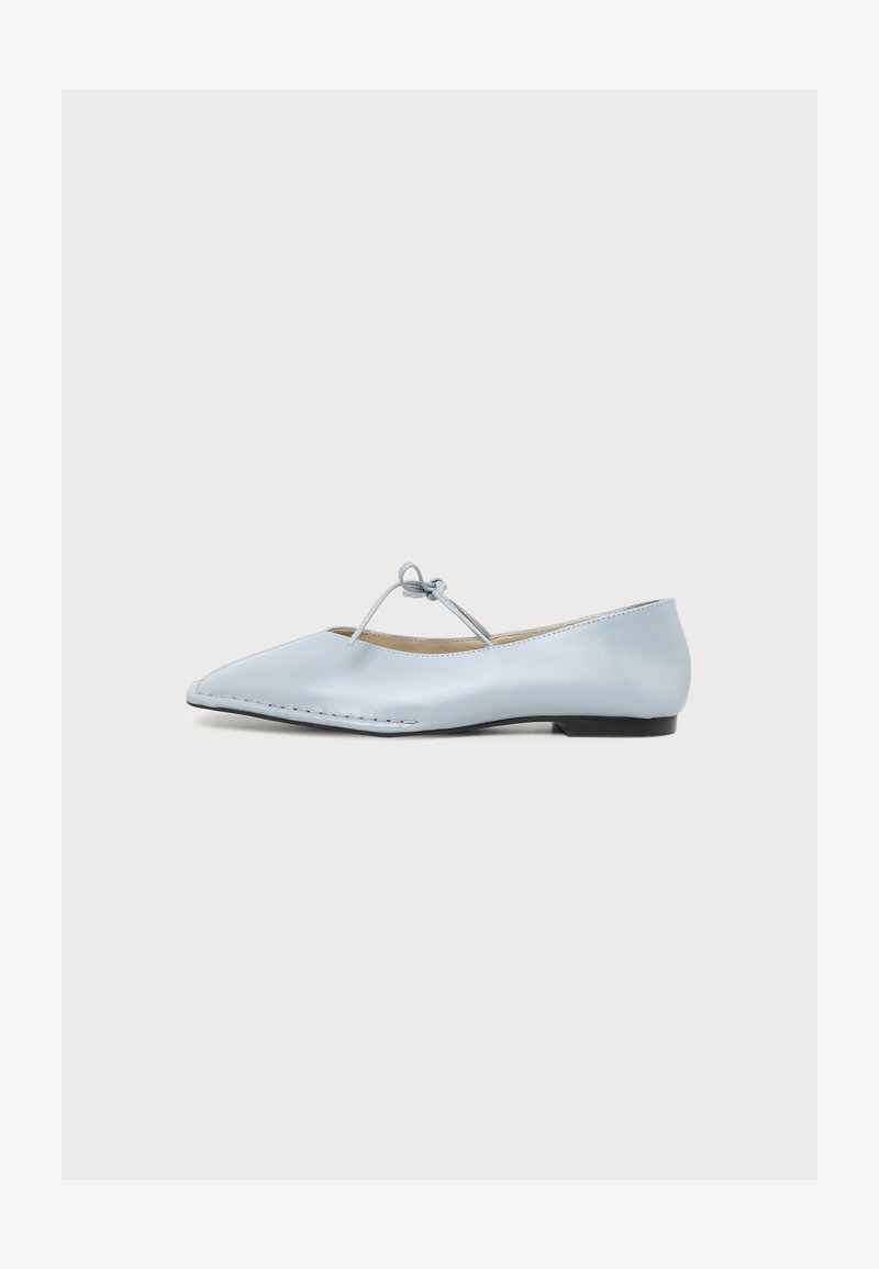 Ballerine en cuir bleu clair avec bout pointu, semelle fine et bride nouée en forme de nœud sur le dessus, sur fond blanc uni.