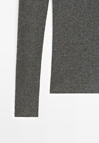 Maglia grigia a maniche lunghe con un tessuto morbido e testurizzato. Presenta un collo arrotondato e un orlo dritto, adatta per un look casual.