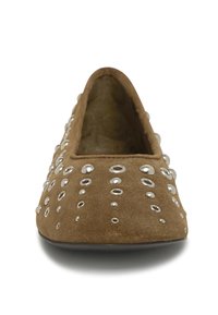 Zapato plano de ante marrón con punta redonda y tachuelas plateadas decorativas dispuestas en diferentes tamaños en la superficie superior.