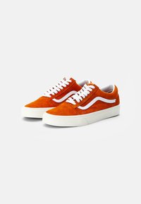 Orange ruskind sneakers med hvide snørebånd, med en hvid sidelinje og en struktureret overdel, monteret på en tyk hvid gummisål.