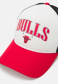 Gorra de camionero con visera roja, parte frontal blanca con el texto "BULLS" y un logo de toro. Panel trasero de malla negra y botón rojo en la parte superior.