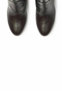 Botas de tobillo de cuero negro con un acabado suave. Diseño elegante y punta afilada. Sin herrajes visibles ni adornos.