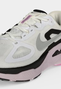 Λευκό και μαύρο παπούτσι για τρέξιμο Nike με ροζ λεπτομέρειες, πλέγμα στα πάνελ, γκρι λογότυπο Swoosh και λευκά κορδόνια.