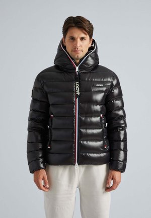 Black puffer jacket with a high neck hood, shiny texture, and vertical quilted design. Features red and white zipper accents and logo patch.