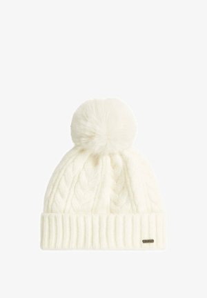 Witte gebreide wintermuts met kabelpatroon, geribde boord en grote pluizige pompon bovenop tegen een witte achtergrond.
