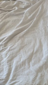 Zmačkaná biela tkanina s jemnou textúrou, ľahký materiál a minimálne viditeľné vzory alebo detaily. Jednotná farba po celej ploche.