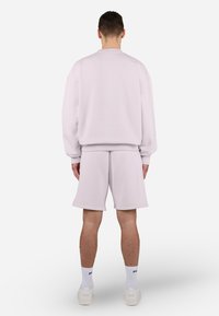 Light gray sweatshirt and matching shorts, made of soft fabric, featuring a relaxed fit and ribbed cuffs. Simple, minimalistic design.