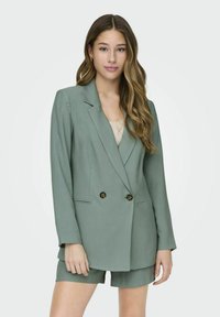 Groen double-breasted blazer van gladde stof, met twee gouden knopen en zijzakken, gecombineerd met bijpassende shorts.