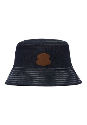 Tummansininen denimin bucket-hattu valkoisilla saumoilla ja ruskealla nahkapaikalla etuosan keskellä.