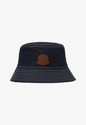 Donkerblauwe denim bucket hat met witte stiksels en een bruine leren patch-embleem aan de voorkant in het midden.