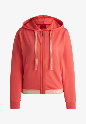 Haut à zip corail avec une capuche, cordons de tirage beige et poches avant. Présente une ceinture de couleur claire avec le logo "HUGO". Texture lisse.