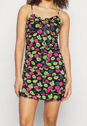Robe noire avec un imprimé floral vibrant en rose et vert, dotée de fines bretelles et d'un design froncé à l'avant avec un détail de nœud central.
