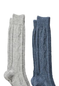 Chaussettes tricotées en gris clair et bleu foncé, présentant des motifs texturés et des bords côtes. La chaussette grise a un motif en losanges ; la bleue a des lignes verticales.