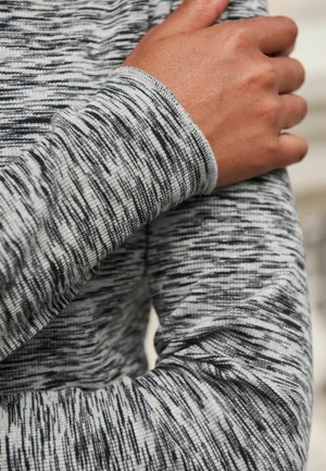 Langärmliges Hemd mit einem einfarbigen Muster in Grautönen, das mit einem strukturierten Stoff und einem taillierten Ärmelabschluss versehen ist.