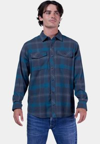 Camisa de cuadros de manga larga en gris oscuro con acentos en verde azulado, que cuenta con un frente abotonado, dos bolsillos en el pecho y un cuello estándar.