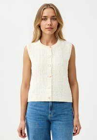 Crèmekleurige, mouwloze gebreide vest met een textuurafwerking, voorzien van een ronde halslijn en zes parelwitte knopen aan de voorkant.