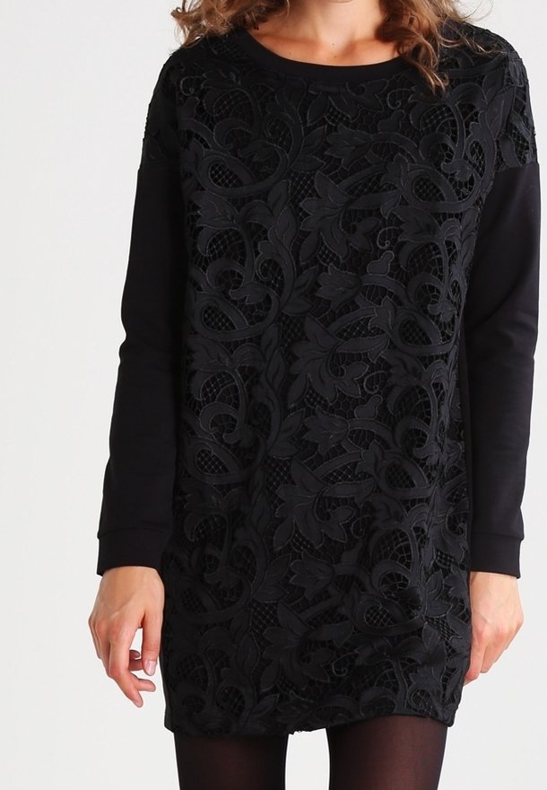 Czarna sukienka z misternym koronkowym wzorem kwiatowym na przodzie, kontrastującym z gładkim, jednolitym czarnym materiałem na rękawach i plecach.