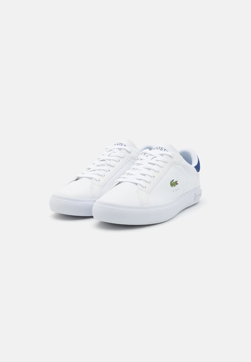 Witte leren sneakers met blauwe accenten, vetersluiting, rubberen zool en Lacoste-logo aan de zijkant en tong. Gladde textuur, lage profiel.