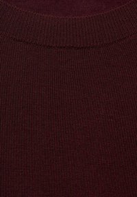 Close-up of a burgundy knitted sweater neckline showing fine ribbed texture and stitching detail.