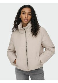 Giacca puffer beige con colletto alto, zip frontale e tasche laterali. Il materiale ha una superficie liscia con una finitura leggermente lucida.