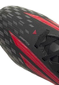 Μαύρο παπούτσι για σπριντ με κόκκινες λεπτομέρειες, μαύρα κορδόνια και υφή λαβής με την ένδειξη "SPRINTWEB" στην επάνω επιφάνεια.