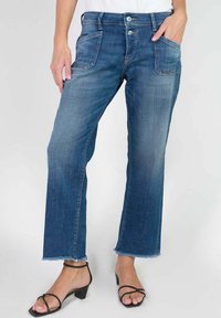 Jean en denim bleu à coupe droite, avec deux poches avant et un ourlet effiloché. Doté d'une fermeture à deux boutons et d'une texture légèrement froissée.