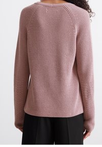 Maglione lavorato a maglia di un delicato rosa, con un motivo a coste testurizzato, maniche raglan e una vestibilità comoda. Presenta un orlo dritto e dettagli laterali sottili.