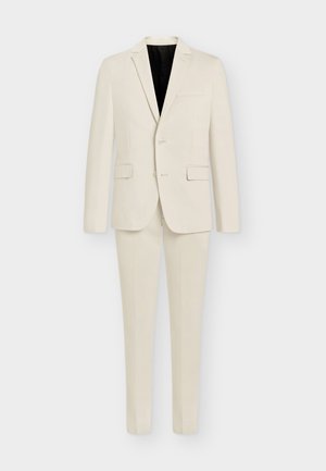 Costume deux pièces en crème clair, comprenant un blazer à un bouton avec des revers notch et un pantalon à taille plate. Tissu doux avec poches.
