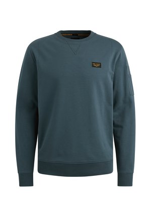 Mørk teal sweatshirt lavet af blødt stof, med rund hals, lange ærmer, ribbede manchetter og en lille mærkepatch på brystet.