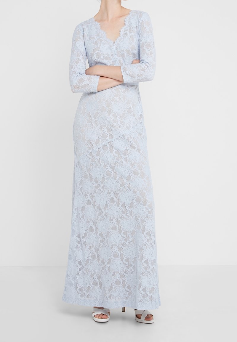Ljusblå spetsklänning med en scalloped V-halsringning och trekvartsärmar, med blommönster och en figurnära siluett.