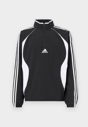 Μαύρο μπουφάν με φερμουάρ και λευκές λεπτομέρειες, που διαθέτει ψηλό γιακά, μακριά μανίκια και τρεις λευκές ρίγες σε κάθε μανίκι. Τα υλικά είναι λεία.