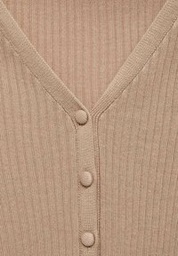 Cardigan bej tricotat cu nervuri, cu nasturi acoperiți de țesătură pe partea din față în formă de V.