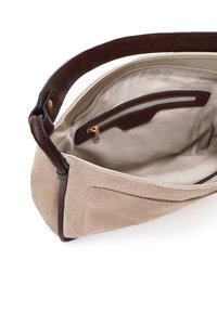 Beige suède handtas met een bruine leren schouderband. Interieur heeft een beige voering en een ritsvak met gouden hardware.