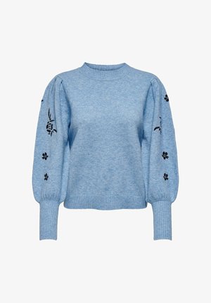 Svetlo modra majica iz mehke pletene tkanine. Ima napihnjene rokave s črnim cvetličnim vezenjem na rokah ter rebraste manšete in spodnji rob.