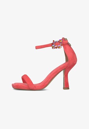 Sandale à talon haut en suède rose corail avec bride à la cheville et boucle ornée de pierres précieuses, talon bloc fin et design à bout ouvert.