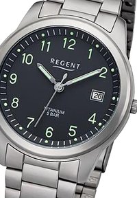 Montre en titane avec un cadran noir, index des heures et aiguilles luminescents verts, et un affichage de la date. Bracelet en métal argenté avec une finition polie.