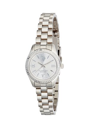 Orologio da polso in acciaio inossidabile argentato con bracciale a maglie, quadrante rotondo, numeri romani alle posizioni 3, 6, 9 e 12, e logo del marchio sul quadrante.