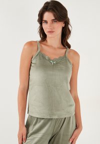 Olijfgroen topje met kantafwerking, verstelbare bandjes, gladde textuur en een klein strikdetail bij de halslijn. Eenvoudig, getailleerd ontwerp.