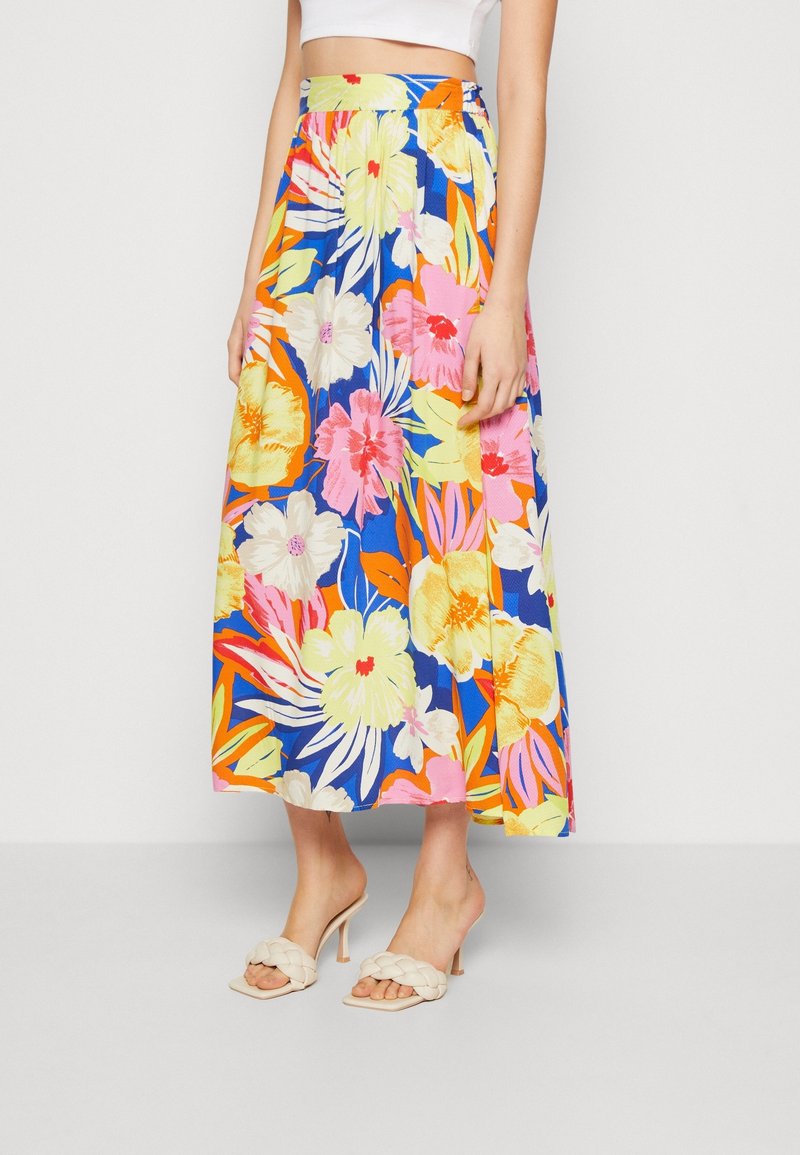 Kukkakuvioinen midi-hame sinisellä taustalla, jossa on suuria keltaisia, vaaleanpunaisia ja vihreitä kukkia. Kumihihnat ja kevyttä kangasta.