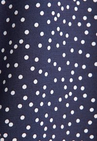 Tessuto navy con un motivo uniforme di pois bianchi, che presenta una consistenza liscia e una finitura leggermente lucida.